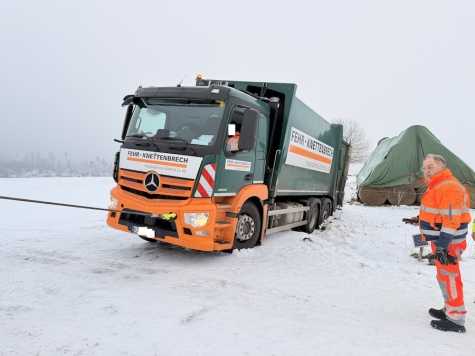 Das schwere Gerät erledigt die Arbeit, doch gesteuert wird es von Hand: Ralf Schmidt (rechts) überwachte den Einsatz und bediente die leistungsstarke Seilwinde präzise mit der Fernbedienung, um weitere Schäden am Müllwagen zu verhindern.