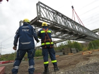 Beim Aushub sichern zwei THW-Einsatzkräfte die Behelfsbrücke.