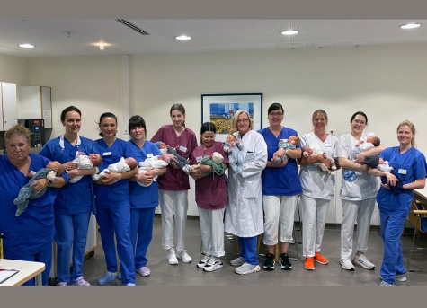 Elf der siebzehn Babys mit dem Team aus Hebammen, Ärzten und Pflegekräften der Geburtsstation.