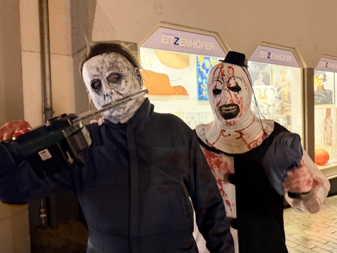 Gruselgestalten in der Frankenberger Fußgängerzone: zwei verkleidete Besucher posieren für ein Foto – die „Kettensäge“ ist nur Requisite.