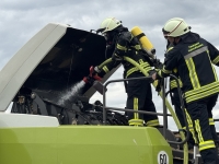 Eine Ballenpresse geriet während der Feldarbeit in Brand. Mitarbeiter zogen sie noch vor Eintreffen der Feuerwehr vom Feld und kuppelten die Zugmaschine ab