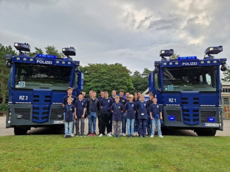 Die Jugendlichen der Jugendfeuerwehr Brilon vor beeindruckenden Wasserwerfern der Bundespolizei in Ratzeburg.