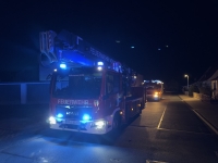 Einsatzkräfte der Feuerwehr unterstützen den Rettungsdienst bei einer Notfalltüröffnung in einem Wohnhaus.